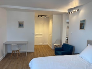 Een hotelkamer met een bed, een bureau, een stoel en een kledingkast.