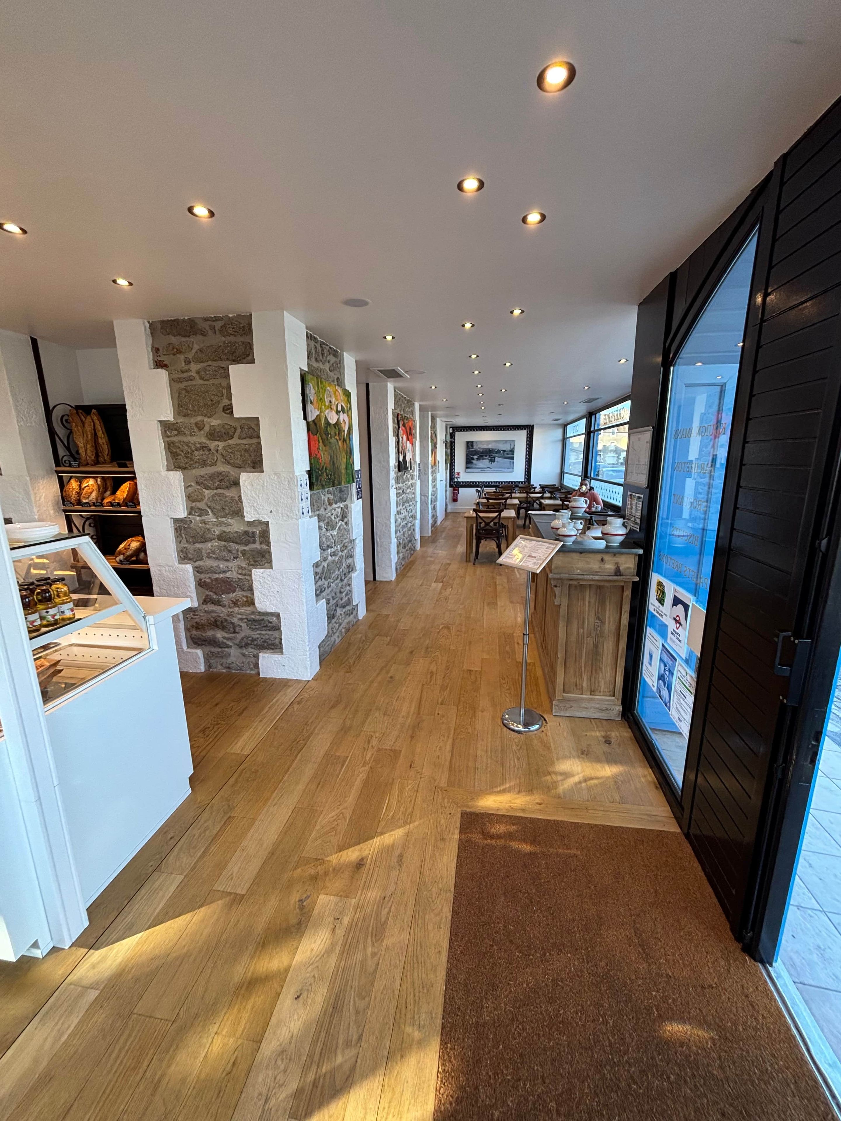 Ein modernes Interieur mit Holzboden, Steinwänden und einer Theke mit Backwaren.