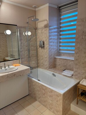 A bathroom with a glass-enclosed shower, a sink with a mirror, and a window with blinds. - TYYANN 8: A 26-square-meter studio equipped with a kitchenette and a bathroom (Plancoët)