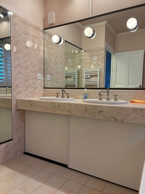 A bathroom with two sinks, a large mirror, and a towel rack. - TYYANN 8: A 26-square-meter studio equipped with a kitchenette and a bathroom (Plancoët)