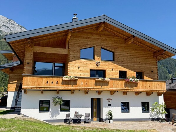 Ein zweigeschossiges Holzhaus mit Balkon, einer Tür und einem Fenster.