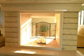A room with a stone wall, a glass partition, and a view of a staircase.