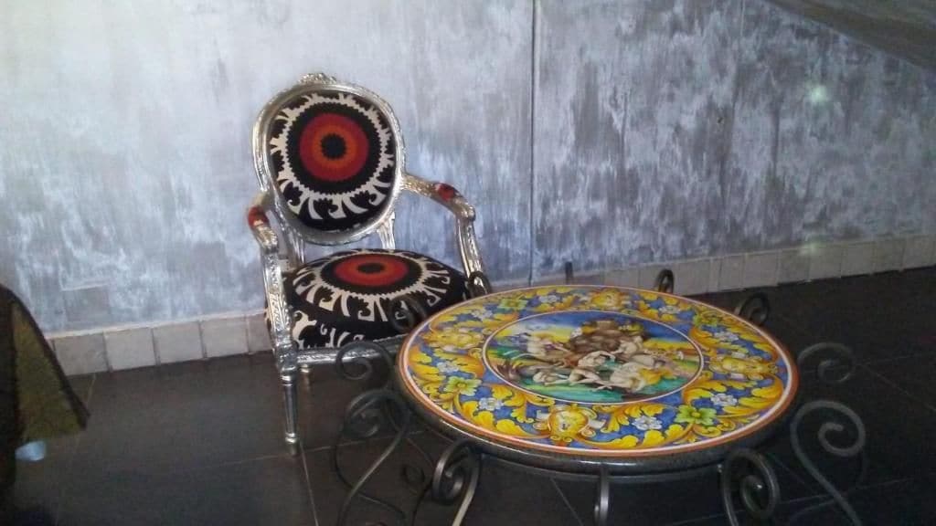 En stol med et mønstret sæde og et rundt bord med et dekorativt design.