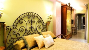 A bed with a metal headboard, two bedside lamps, and a wooden side table. - Animosa Suite (Castiglione di Sicilia)