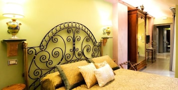 A bed with a metal headboard, two bedside lamps, and a wooden side table.