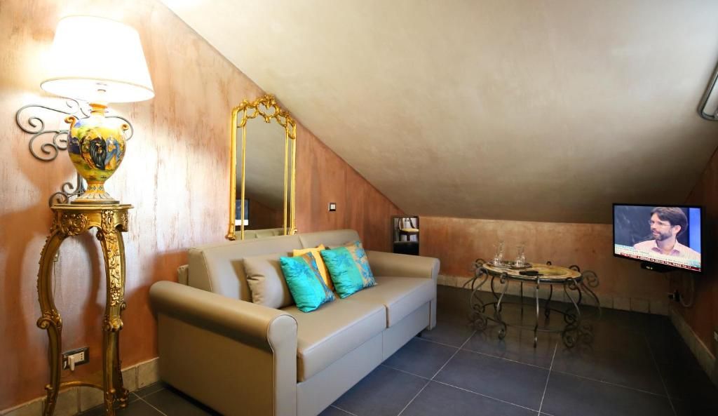 Una sala de estar con un sofá, una televisión, una lámpara y una mesa.