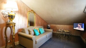 A living room with a sofa, a television, a lamp, and a table. - Animosa Suite (Castiglione di Sicilia)