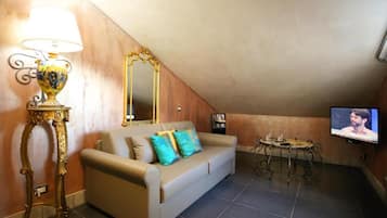 Una sala de estar con un sofá, una televisión, una lámpara y una mesa.