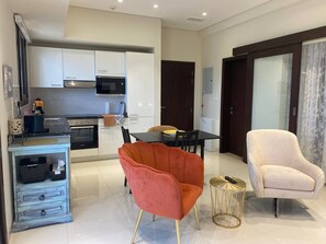 A modern living space with a kitchen, dining area, and seating. - Arcadia Salalah Apartment (Salalah)