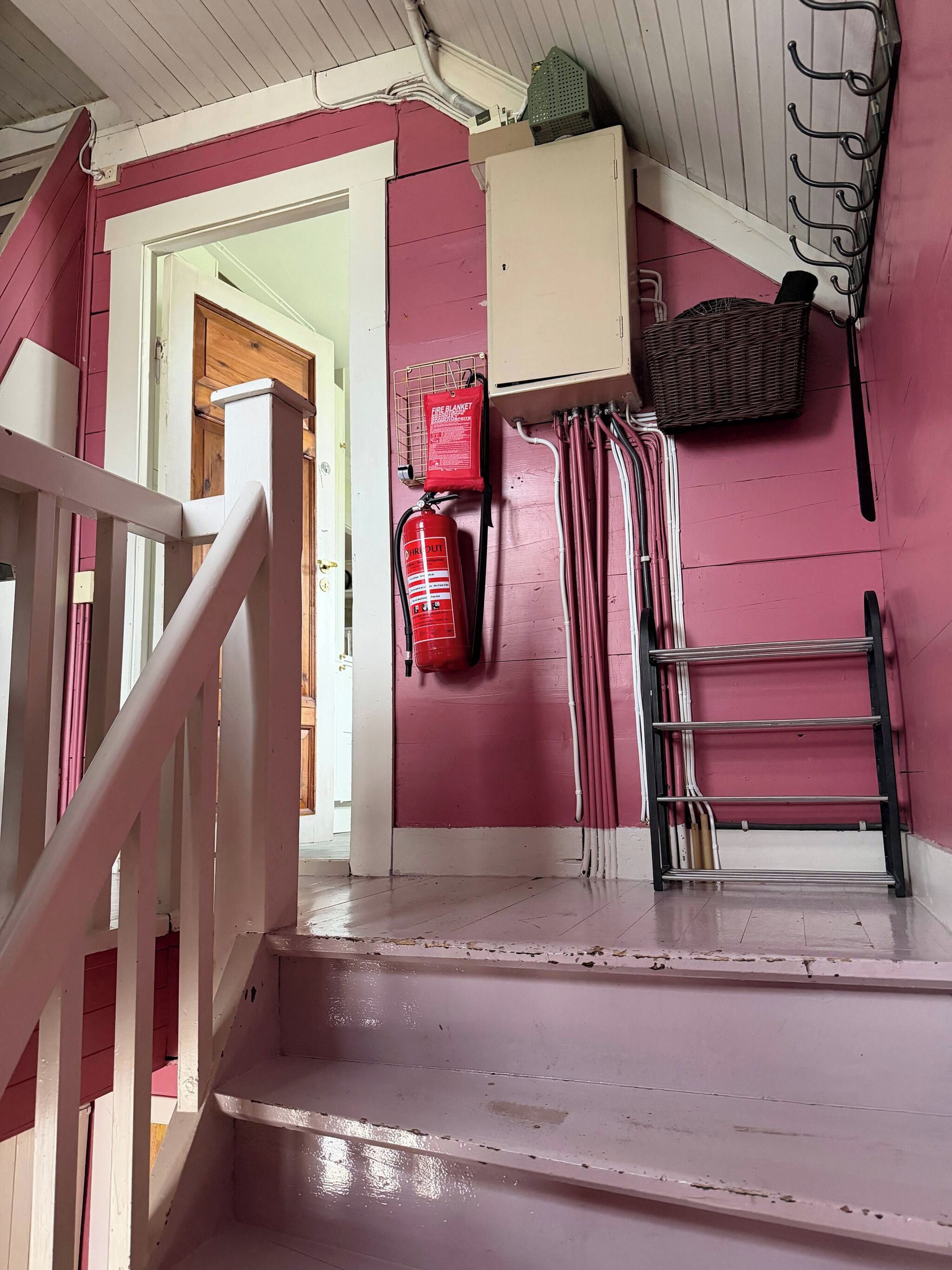Un escalier avec un extincteur et une couverture anti-feu fixés au mur.