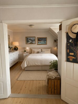 A bedroom with a bed, bedside tables, a nightstand, a lamp, a mirror, a dresser, a window, and a door. - Central 2-Bedroom Sea View Apartment (Volda)