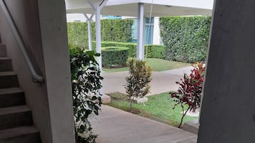 A covered outdoor area with a concrete staircase leading to a sidewalk.