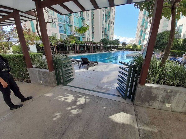 A pool area with lounge chairs and a pergola structure.