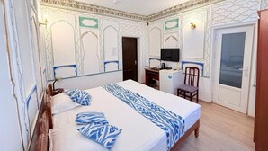 A hotel room with a bed, a desk, a chair, and a television. - Ismat Premium Guest House Bukhara (Bukhara)