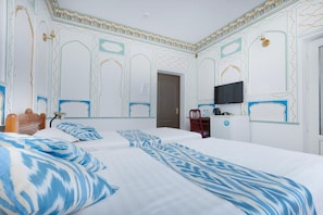 Una habitación de hotel con una cama grande, un escritorio, una silla y un televisor.