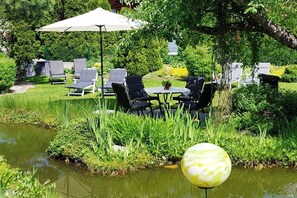 A garden with a pond, outdoor seating, and a gazebo. - Alpine garden in the holiday home Weimar (Ellmau)