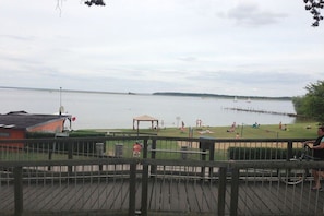 Ein Seeblick mit einer Holzterrasse, einem Pavillon und einem entfernten Steg.