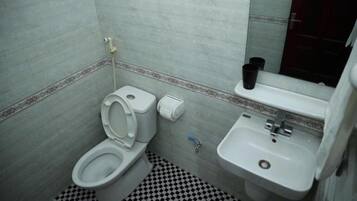 Un bagno piccolo con il water, un lavandino e uno specchio.