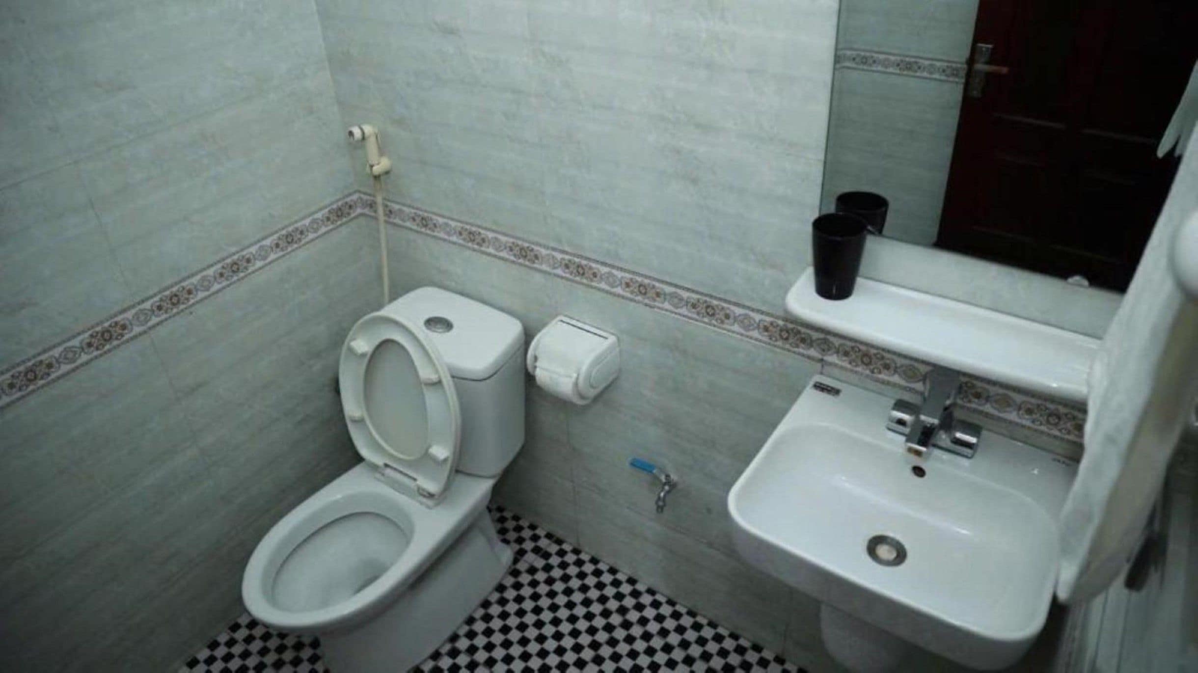Un baño pequeño con inodoro, lavabo y espejo.