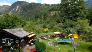 A rustic cabin with a garden, a ping pong table, and a children's play area with a slide. - Maple view in the Tasser house (Mayrhofen)