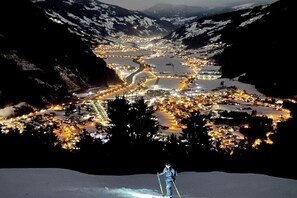 Een nachtzicht van een met sneeuw bedekte vallei, met een stad verlicht door straatverlichting.