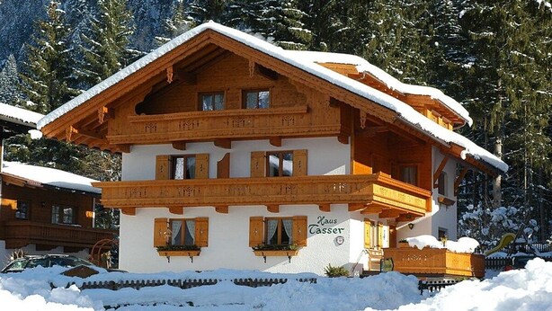 A traditional chalet with a wooden facade, multiple balconies, and a sign indicating 'Haus Tasser'. - Maple view in the Tasser house (Mayrhofen)