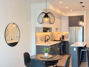 Une cuisine moderne avec un coin repas, une table ronde et des chaises.