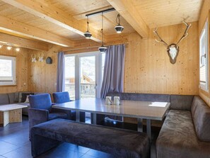A wooden interior with a dining table, benches, and a mounted animal head on the wall. - Cabin With 1 Bedroom (Sankt Georgen am Kreischberg)