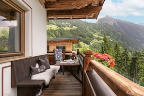 A wooden deck with a bench and table, overlooking a mountainous landscape. - Kolm in Christina's country house (Mayrhofen)