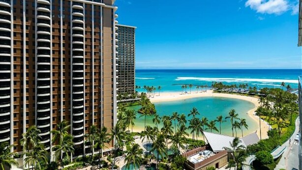 Un hotel con vista a la playa, que incluye una playa de arena y el océano.