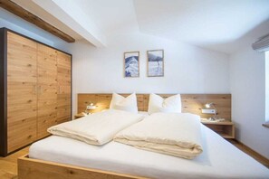 Een slaapkamer met een houten bed, nachtkastjes en een kledingkast.