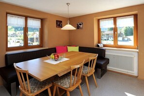 A dining area with a wooden table, chairs, a bench, and a radiator. - Holiday apartment with 4 bedrooms (Schoppernau)