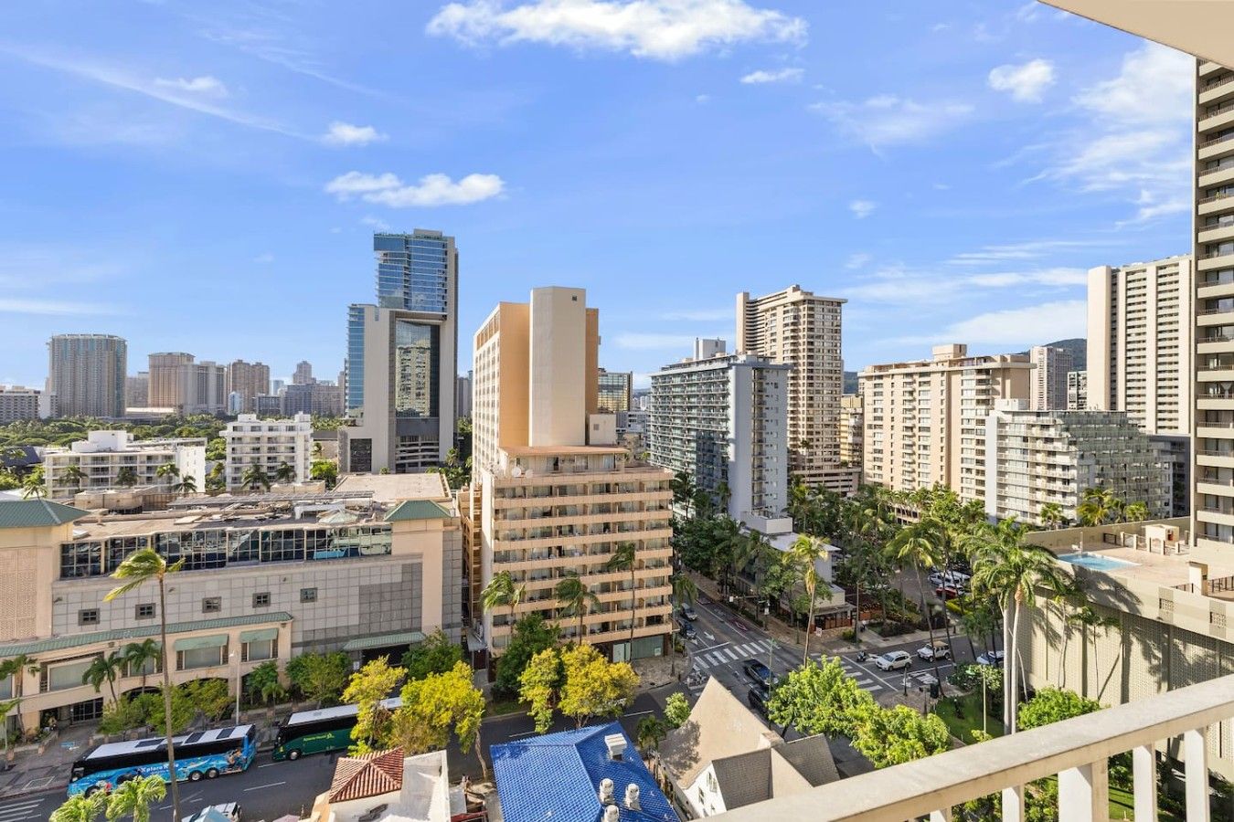 A cityscape with high-rise buildings, a clear sky, and a street with vehicles.