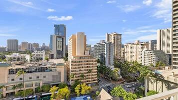 A cityscape with high-rise buildings, a clear sky, and a street with vehicles.