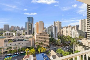 Paisatge urbà amb edificis alts, cel clar i carrer amb vehicles.