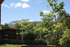 A wooden cabin with a view of a mountain range. - Holiday home in Riezlern with swimming pool (Riezlern)