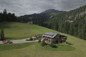 Eine Lodge mit einem großen Gebäude, einem Parkplatz und einer Bergkulisse.