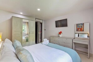 A bedroom with a bed, a wardrobe, a desk, a TV, and a painting. - Pratumnak Hill 2BR Sea View (PH3) (Banglamung)