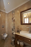 Un baño con inodoro, lavamanos y ducha.