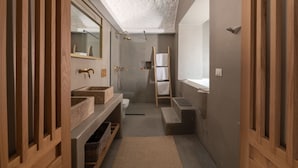 A modern bathroom with a large mirror, two sinks, a shower, and a wooden ladder. - Kaminos Boutique Hotel (Symi)