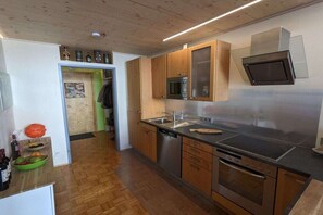 Eine moderne Küche mit Edelstahlgeräten, Holzschränken und einer eingebauten Mikrowelle.