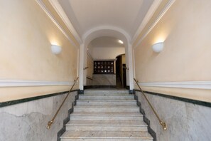 A grand staircase with marble steps and brass handrails, leading to a landing with a dark wooden door. - A spacious and bright 87-square-meter apartment perfect for six people, located on the first floor of a building (equipped with an elevator, though there are a few steps to reach it; NOT suitable for people with disabilities).The property is centrally lo (Rome)