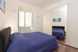 A bedroom with a bed, a window, a radiator, and a mirror. - A spacious and bright 87-square-meter apartment perfect for six people, located on the first floor of a building (equipped with an elevator, though there are a few steps to reach it; NOT suitable for people with disabilities).The property is centrally lo (Rome)
