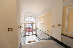 A hallway with a marble floor, a door with a glass panel, and a red car visible outside. - A spacious and bright 87-square-meter apartment perfect for six people, located on the first floor of a building (equipped with an elevator, though there are a few steps to reach it; NOT suitable for people with disabilities).The property is centrally lo (Rome)