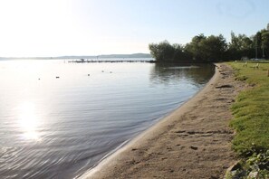 A calm lake with a sandy beach and a pier extending into the water. - Holiday home with 5 bedrooms (Röbel an der Müritz)