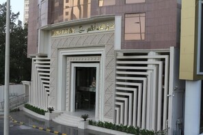 A building entrance with a modern design, featuring a geometric facade and a clear entrance. - Al Qimah Atlas Hotel (Makkah)