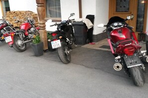 A row of motorcycles parked outside a building with a wooden door and windows. - Holiday apartment with 1 bedroom (Pettneu am Arlberg)