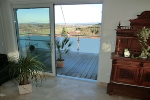 Una habitación con puerta de vidrio corredera que da a un balcón con vistas al paisaje.