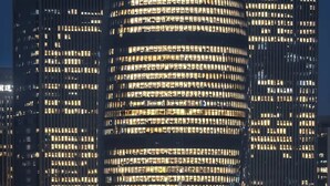 Ein Hochhaus mit mehreren Etagen, das durch ein modernes Architekturdesign mit einer geschwungenen Fassade und zahlreichen Fenstern gekennzeichnet ist.