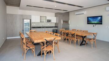 A modern kitchen with a dining area, equipped with a refrigerator, microwave, and oven.